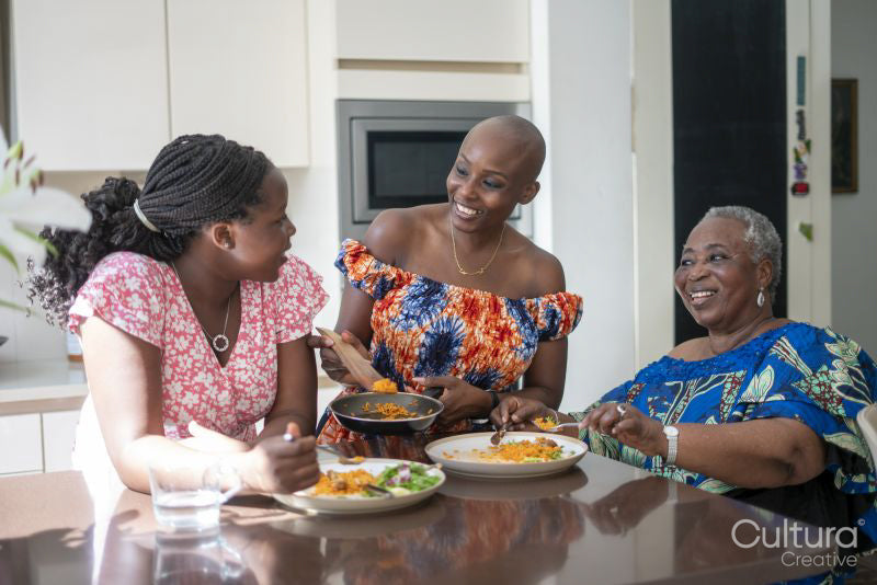 Teenage girl with mother and grandmother eating dinner at table