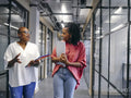 Two women walking in office hallway