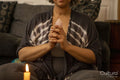 Woman meditating with healing crystal in living room