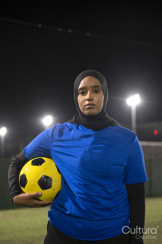 Portrait of female soccer player holding ball