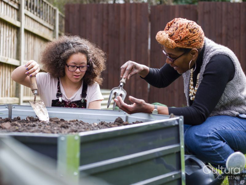 Mother and daughter gardening in backyard