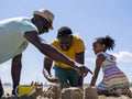 Family with daughter building sand castles on beach