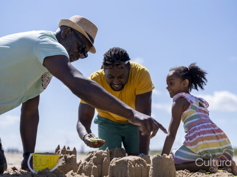 Family with daughter building sand castles on beach