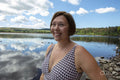 Smiling woman in swimsuit standing on lakeshore, Yorkshire, UK