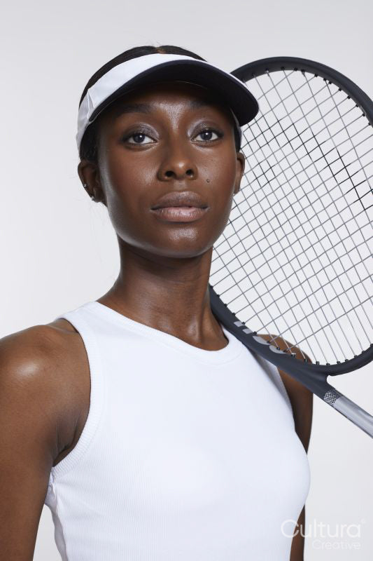 Studio portrait of athletic woman with tennis racket