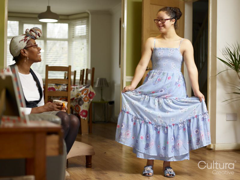 Smiling mother and daughter with Down syndrome in blue dress