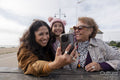 Grandmother, mother and daughter taking selfie with smart phone