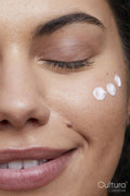Close-up of young woman applying face cream