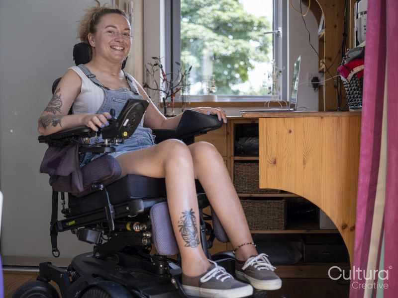 Portrait of smiling woman in electric wheelchair