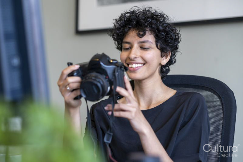 Young female photographer holding camera