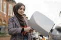 Woman wearing hijab charging electric car