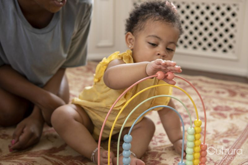 Mother playing with baby daughter at home
