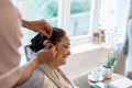 Nurse helps senior lady putting on hearing aid at nursing home