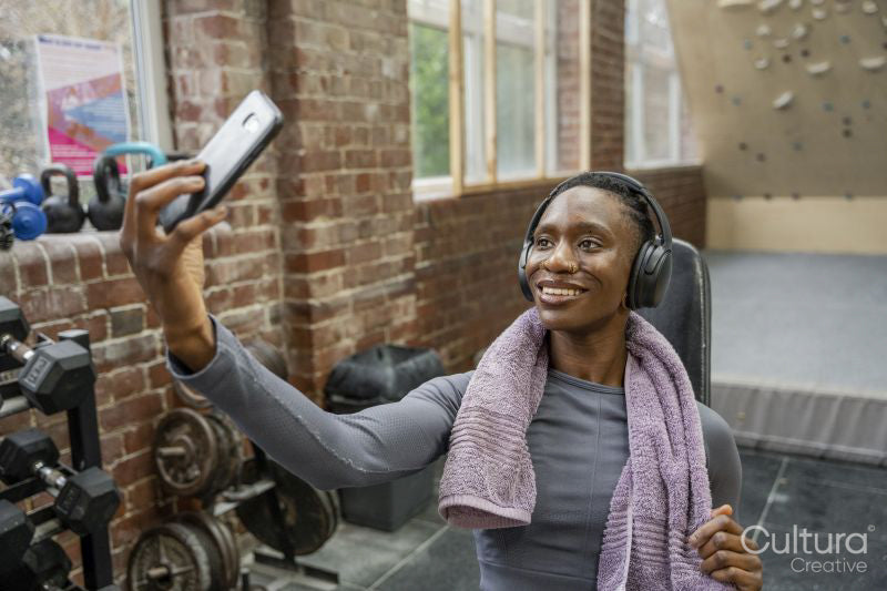 Smiling athletic woman taking selfie at gym
