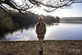 Portrait of young woman standing at lake