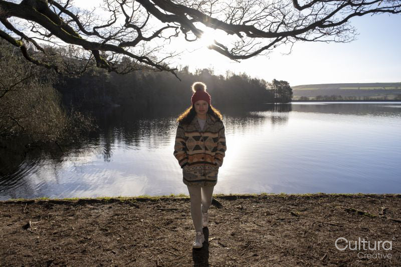 Portrait of young woman standing at lake