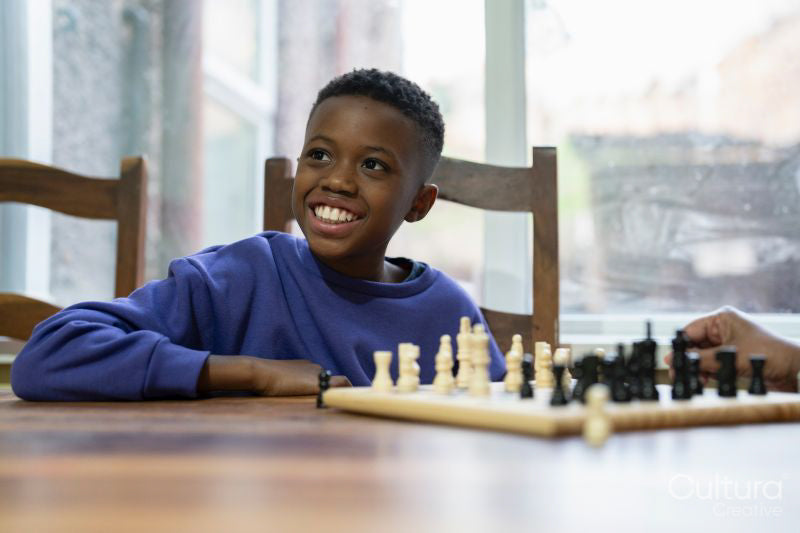 Grandmother and grandson playing chess at home