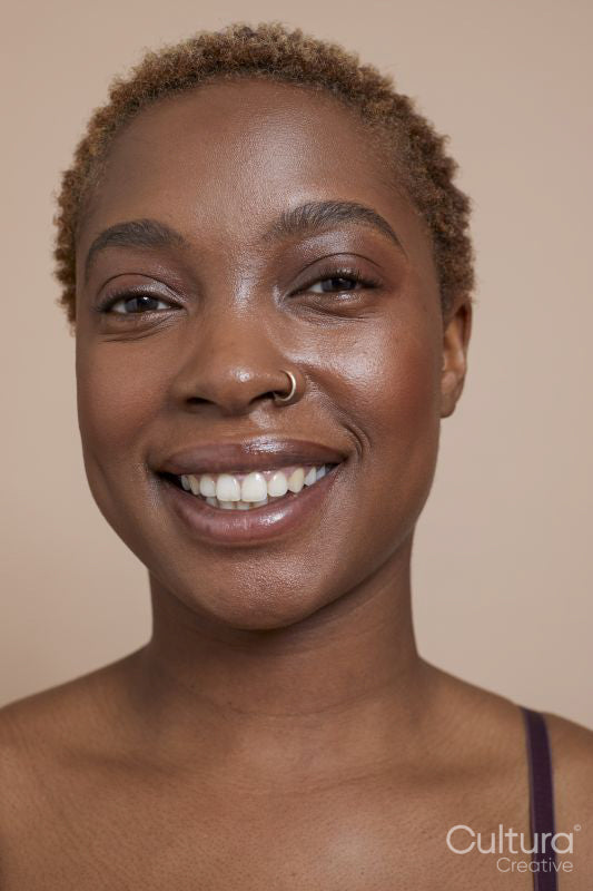 Studio portrait of smiling woman with nose ring