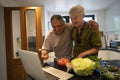 Smiling senior couple looking at laptop in kitchen