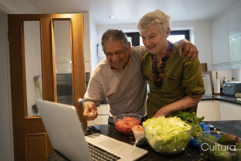 Smiling senior couple looking at laptop in kitchen