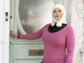 Sutton,Smiling woman in headscarf and sports clothing leaving house