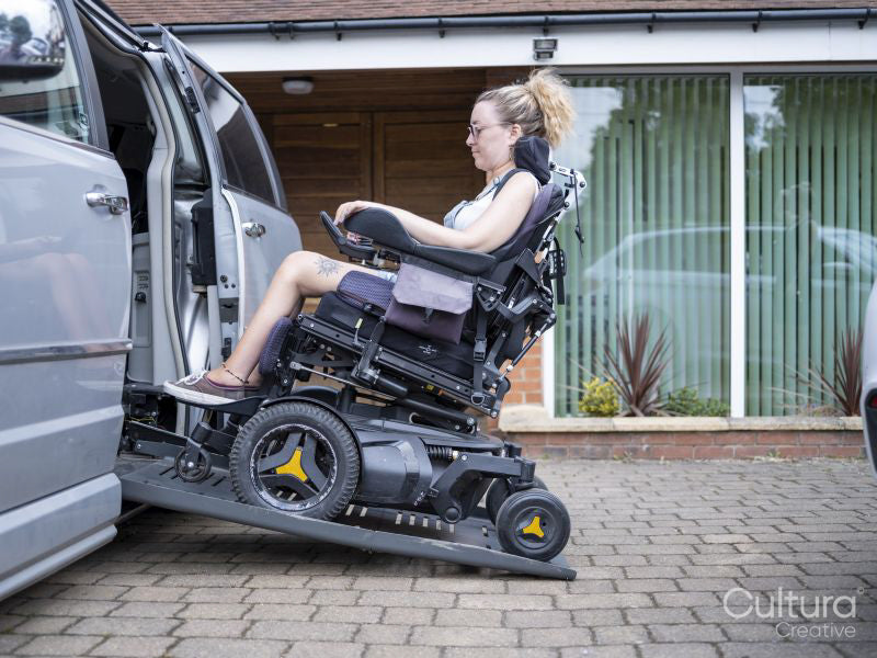 Woman in electric wheelchair getting in van