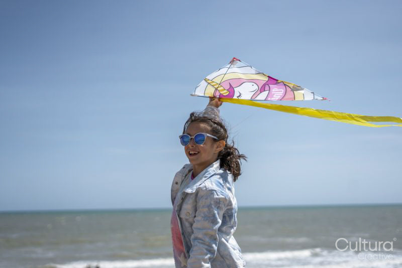 Girl flying kite on beach