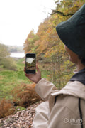 Woman photographing landscape while hiking
