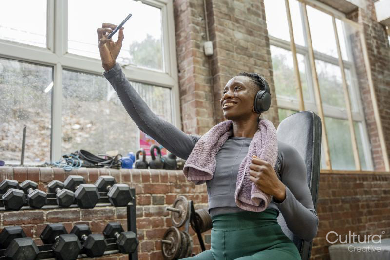 Smiling athletic woman taking selfie at gym