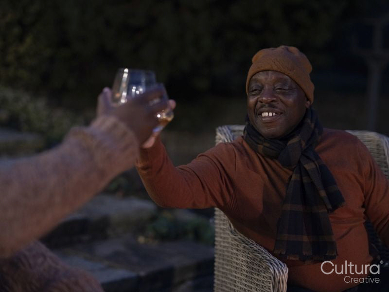 Men sitting on patio and raising toast