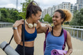 Laughing female friends going to practice yoga