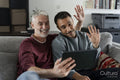 Smiling male couple taking selfie on sofa