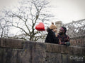 Smiling couple with heart shaped balloon leaning on wall