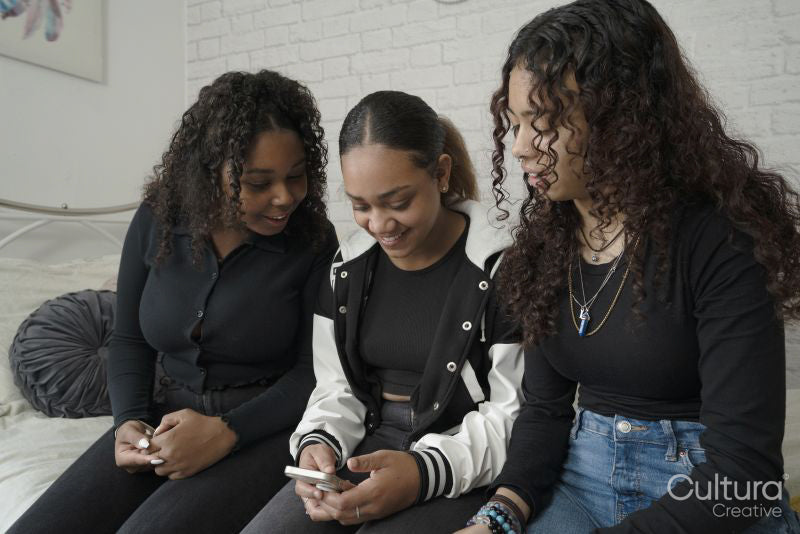 Teenage girls using smart phone in bedroom