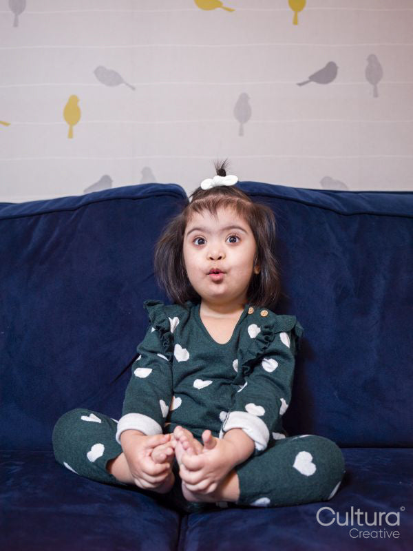 Portrait of girl with Down syndrome sitting on sofa
