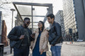 Smiling friends using phone on campus