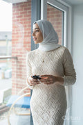 Mid adult woman in hijab looking through window