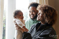 Smiling parents looking at baby daughter at home