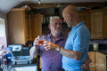 Senior male couple raising toast in kitchen