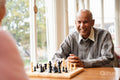 Smiling senior man playing chess in nursing home