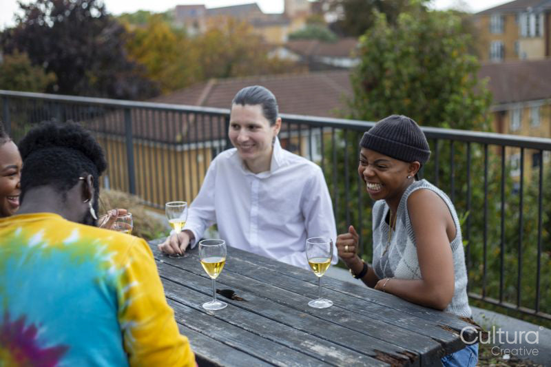 Friends laughing at table on rooftop terrace