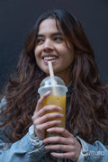 Portrait of cheerful young woman drinking bubble tea