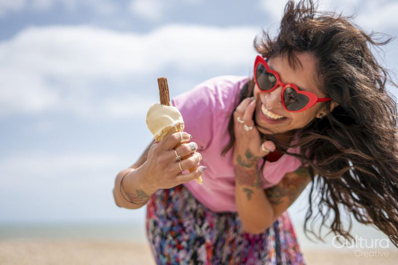 Smiling woman eating ice cream on beach