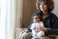 Young mother holding baby girl on lap at home
