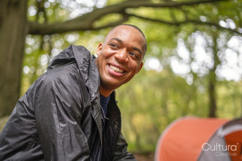 Smiling man camping in forest