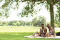 Louisiana, couple with dogs having picnic on lawn in park