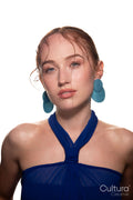 Studio portrait of a woman in a blue dress and large blue earrings