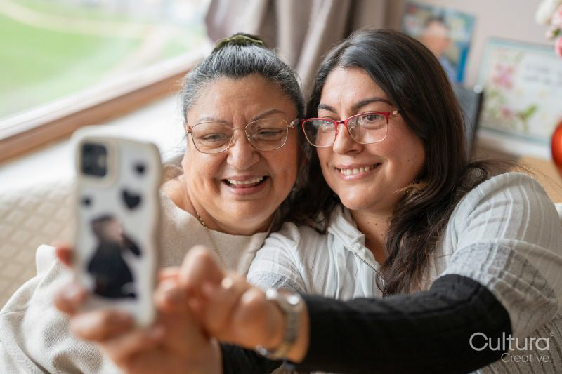 Senior mother and mature daughter taking selfie at home