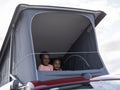 Siblings in camper van rooftop tent