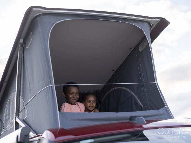 Siblings in camper van rooftop tent
